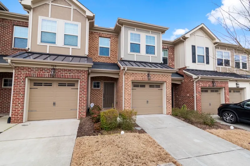 Modern townhomes with attached garages and driveways — representative exterior, not this specific building.