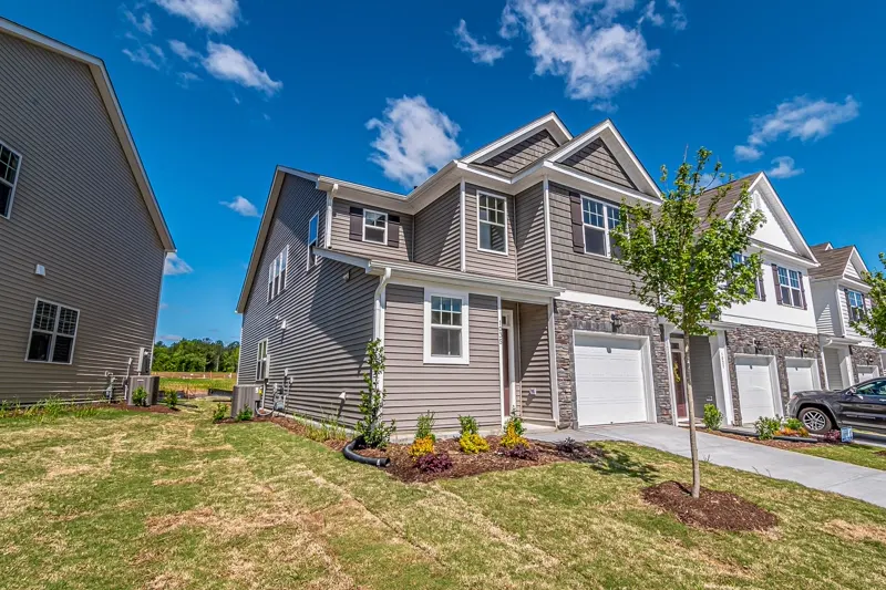 Townhomes with attached garages on a tree-lined street — representative exterior.