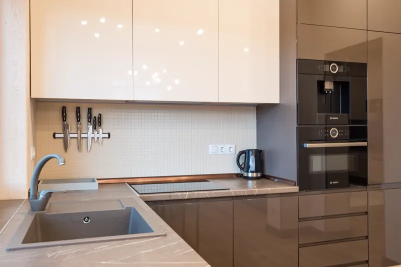 Kitchen with white cabinetry and integrated appliances