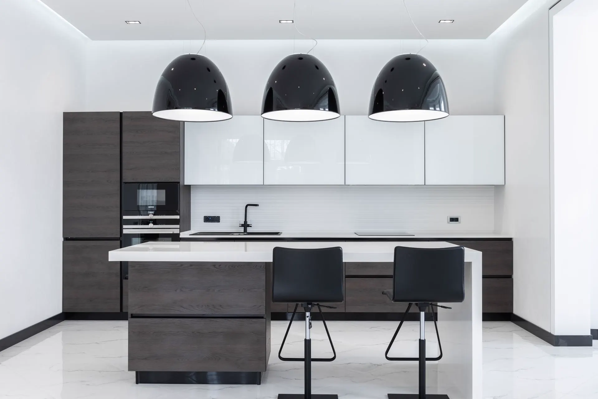 Modern kitchen with dark cabinetry, pendant lighting, and an island — representative interior.